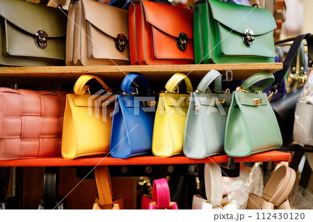 Close up of different leather bags on market. Modern colorful bags for sale. Womanly accessories Close up of different leather bags on market. Modern colorful bags for sale. Womanly accessories 112430120