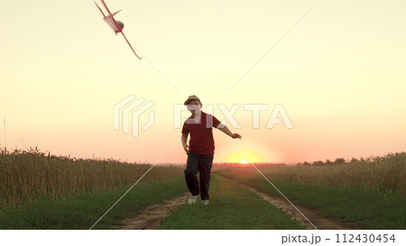 child kid boy Flying kite Bright sunset, children running flying kite Evening sky park sunset, boy running happily playing along country road, Running boy, kid child son schoolboy running, wind flying 112430454