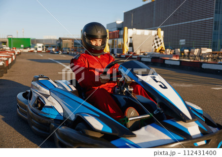 Go-cart racer moving fast on open air motor racing track 112431400