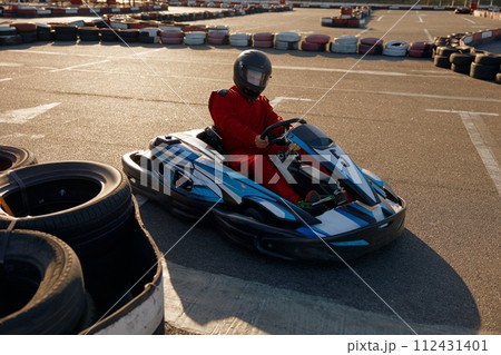 Diver racing on go-cart track outdoors enjoying competitive activity Diver racing on go-cart track outdoors enjoying competitive activity 112431401
