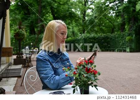A girl takes a selfie in the park. A fashionable girl takes a selfie on a smartphone 112431468