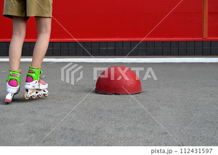 Full-length portrait of a smiling girl with long hair on roller skates 112431597