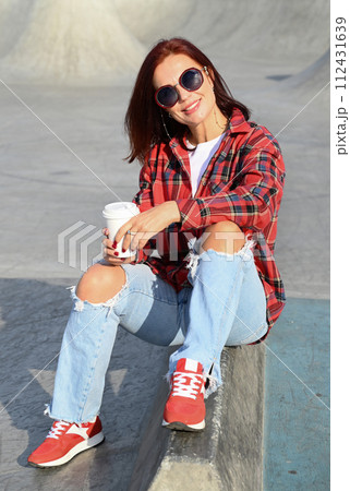 a confident young woman walks through the streets of the city, a woman smiles and enjoys life 112431639