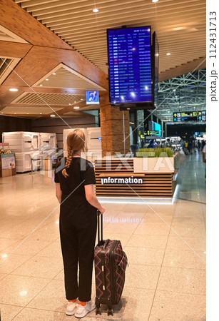 Faceless girl in green coat holds passport with ticket and yellow suitcase airport. Airplane travel concept. Faceless girl in green coat holds passport with ticket and yellow suitcase airport. Airplane travel concept. 112431713