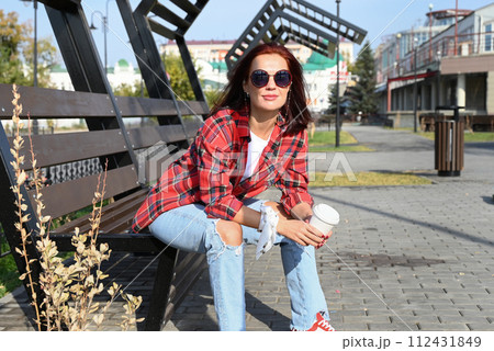 a confident young woman walks through the streets of the city, a woman smiles and enjoys life a confident young woman walks through the streets of the city, a woman smiles and enjoys life 112431849