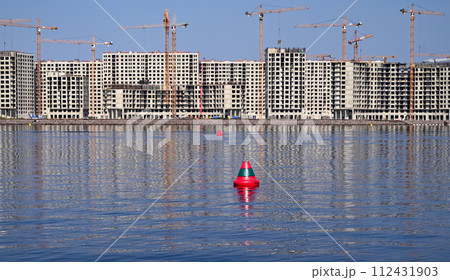Construction site of new buildings, view from the river to the new neighborhood Construction site of new buildings, view from the river to the new neighborhood 112431903