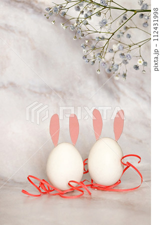Easter composition of eggs and flowers on a light background. Easter bunny. A gentle greeting card for the Easter holiday.Top view, copy location, flat layout. 112431998
