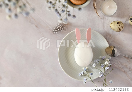 Easter composition of eggs and flowers on a light background. Easter bunny. A gentle greeting card for the Easter holiday.Top view, copy location, flat layout. Easter composition of eggs and flowers on a light background. Easter bunny. A gentle greeting card for the Easter holiday.Top view, copy location, flat layout. 112432158