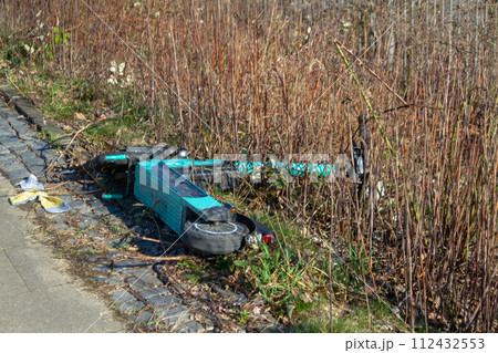 Electric scooter abandoned. Ein im Gras liegender Elektroroller. Electric scooter abandoned. Ein im Gras liegender Elektroroller. 112432553