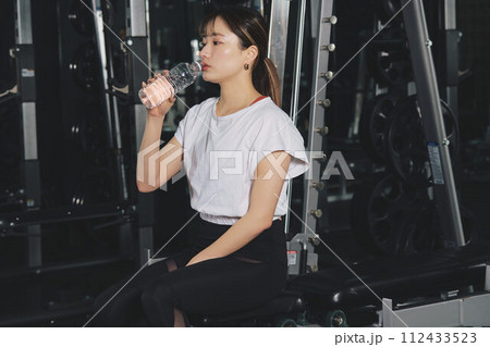 トレーニングジムで水を飲む女性 トレーニングジムで水を飲む女性 112433523