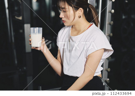 トレーニングジムでプロテインを飲む女性 トレーニングジムでプロテインを飲む女性 112433694