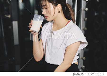 トレーニングジムでプロテインを飲む女性 トレーニングジムでプロテインを飲む女性 112433695