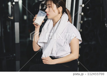 トレーニングジムでプロテインを飲む女性 トレーニングジムでプロテインを飲む女性 112433700