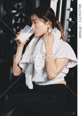 トレーニングジムでプロテインを飲む女性 112433706
