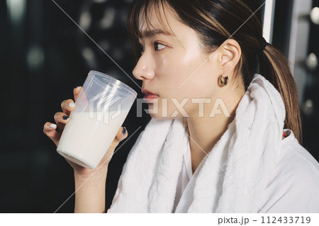 トレーニングジムでプロテインを飲む女性 112433719