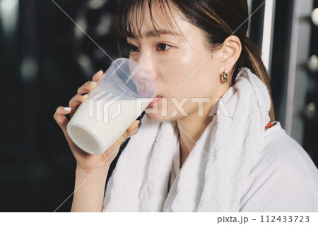 トレーニングジムでプロテインを飲む女性 トレーニングジムでプロテインを飲む女性 112433723