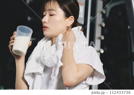トレーニングジムでプロテインを飲む女性 112433736