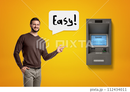 Man pointing to an ATM machine saying 'Easy' Man pointing to an ATM machine saying 'Easy' 112434011