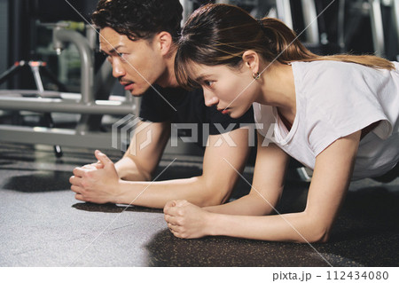 トレーニングジムで真剣な表情をする若い男性パーソナルトレーナー 112434080