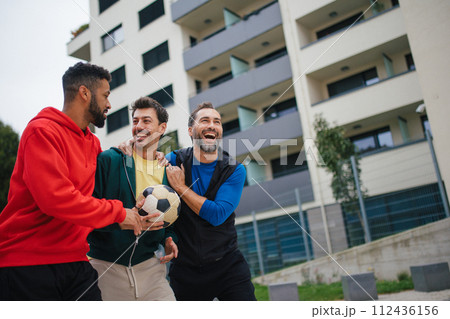 Best friends playing sport outdoors, having fun, competing. Playing football at local field, enjoying exercise together. Concept of male friendship, bromance. Best friends playing sport outdoors, having fun, competing. Playing football at local field, enjoying exercise together. Concept of male friendship, bromance. 112436156