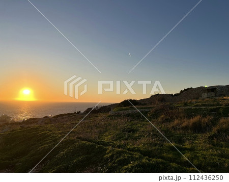 Beautiful and colourful sunset at Blue Grotto, complex of seven caves found at Wied iz-Zurrieq harbour coast of Malta. Caves are located on the coastline opposite to the small islet of Filfla. Beautiful and colourful sunset at Blue Grotto, complex of seven caves found at Wied iz-Zurrieq harbour coast of Malta. Caves are located on the coastline opposite to the small islet of Filfla. 112436250