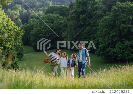Family on walk in forest, going through meadow. Picking mushrooms, herbs, flowers picking in basket, foraging. Concept of family ecological hobby in nature. Family on walk in forest, going through meadow. Picking mushrooms, herbs, flowers picking in basket, foraging. Concept of family ecological hobby in nature. 112436281