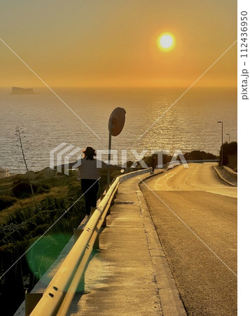 Road with beautiful and colourful sunset at Blue Grotto, complex of seven caves found at Wied iz-Zurrieq harbour coast of Malta.  112436950