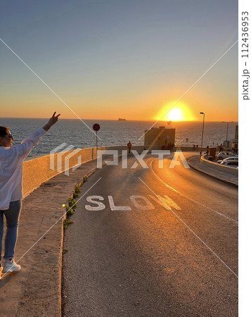 Road with beautiful and colourful sunset at Blue Grotto, complex of seven caves found at Wied iz-Zurrieq harbour coast of Malta. Road with beautiful and colourful sunset at Blue Grotto, complex of seven caves found at Wied iz-Zurrieq harbour coast of Malta. 112436953