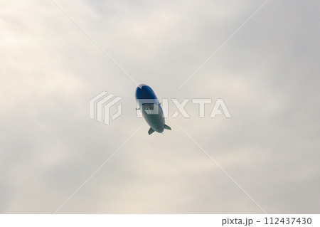 Blimp, airship or dirigible flying in sky 112437430