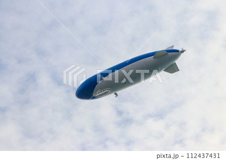 Blimp, airship or dirigible flying in sky Blimp, airship or dirigible flying in sky 112437431
