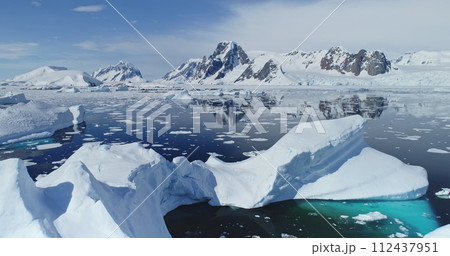 Close up melting iceberg on waters of Southern Ocean to ice-shelves, glaciers and mountains aerial. Distinct natural environments of Antarctica. Changing climate and global warming problem, rising sea Close up melting iceberg on waters of Southern Ocean to ice-shelves, glaciers and mountains aerial. Distinct natural environments of Antarctica. Changing climate and global warming problem, rising sea 112437951