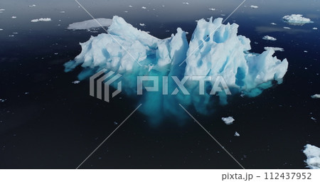 Antarctica melting iceberg reflection at blue ocean water aerial view. Antarctic nature landscape with environmental problem of global warming. Arctic winter landscape with climate change concept Antarctica melting iceberg reflection at blue ocean water aerial view. Antarctic nature landscape with environmental problem of global warming. Arctic winter landscape with climate change concept 112437952