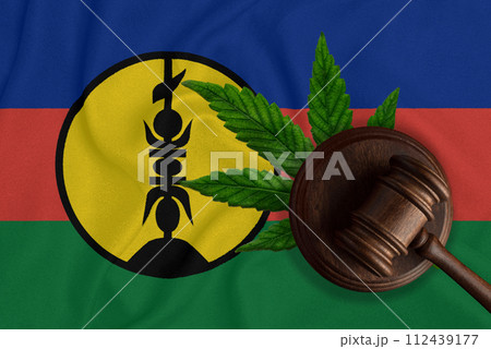 Flag of New Caledonia, green fresh cannabis leaf and Judicial wooden gavel. Illegal cultivation and distribution. Medical use. 112439177