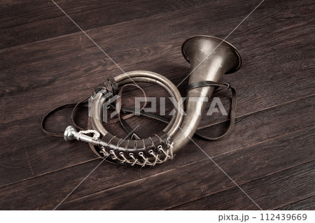 Hunting horn on rustic wood plank. Hunting horn on rustic wood plank. 112439669