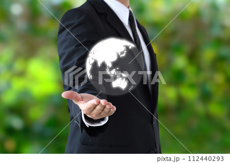 新緑を背景に地球を掲げるビジネスマン 112440293