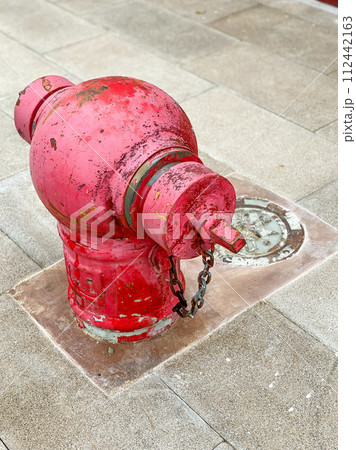 Old public fire hydrant on the footpath 112442163