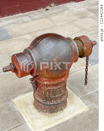 Old public fire hydrant on the footpath 112442164