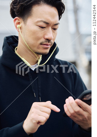 イヤホンで音楽を聴く男性 イヤホンで音楽を聴く男性 112442544