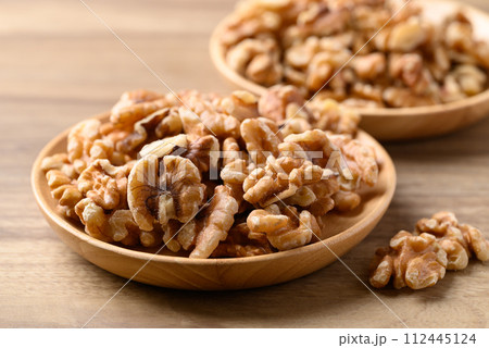 Organic raw walnuts in wooden plate, Food ingredient 112445124