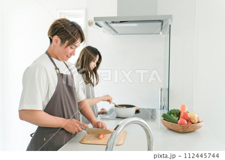 家のキッチンで一緒に料理を作る若いアジア人夫婦 家のキッチンで一緒に料理を作る若いアジア人夫婦 112445744