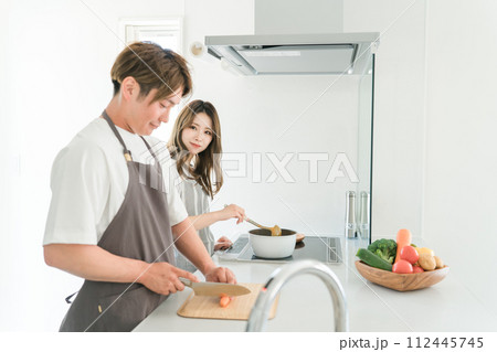 家のキッチンで一緒に料理を作る若いアジア人夫婦 家のキッチンで一緒に料理を作る若いアジア人夫婦 112445745