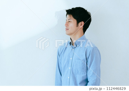 白壁を背景に立つ男性 白壁を背景に立つ男性 112446829