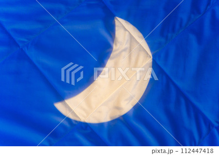 Crescent moonlight on blanket at night in bedroom, background. Conceptual background for products with melatonin, cannabis oil to relax and improve the quality of sleep at night while you sleep Crescent moonlight on blanket at night in bedroom, background. Conceptual background for products with melatonin, cannabis oil to relax and improve the quality of sleep at night while you sleep 112447418