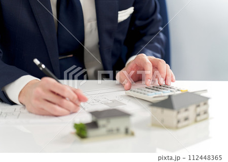 不動産の間取りを計算するビジネスマン 不動産の間取りを計算するビジネスマン 112448365