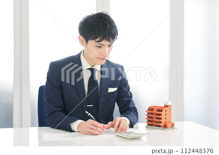 マンションの間取りを計算するビジネスマン 112448376