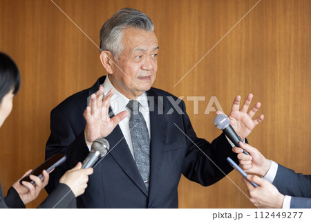 報道陣の質疑応答に応えるシニアビジネスマン 112449277