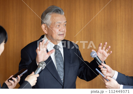 報道陣の質疑応答に応えるシニアビジネスマン 112449371