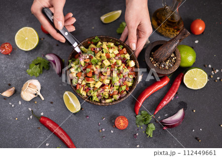 traditional salsa dip snack in wooden bowl on a table with ingredients traditional salsa dip snack in wooden bowl on a table with ingredients 112449661