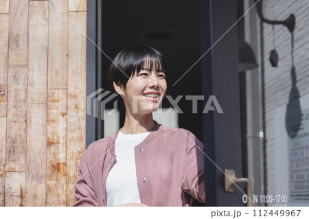 ドアを開ける女性 112449967