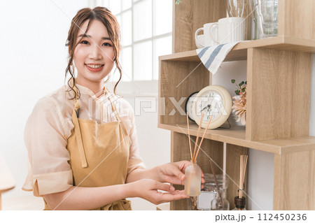 雑貨屋・アパレル・インテリア・クラフトショップでアロマディフューザーを持つ女性スタッフ 雑貨屋・アパレル・インテリア・クラフトショップでアロマディフューザーを持つ女性スタッフ 112450236
